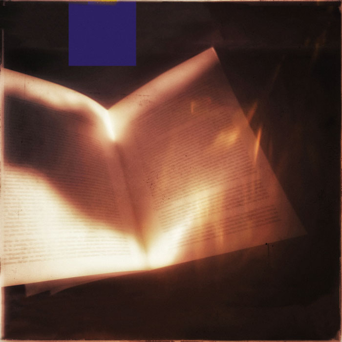 un libro abierto con resplandores de sol y un cuadrado azul